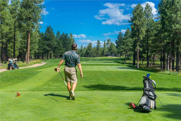 Un golfeur marche sur le parcours du Club de golf Hériot.