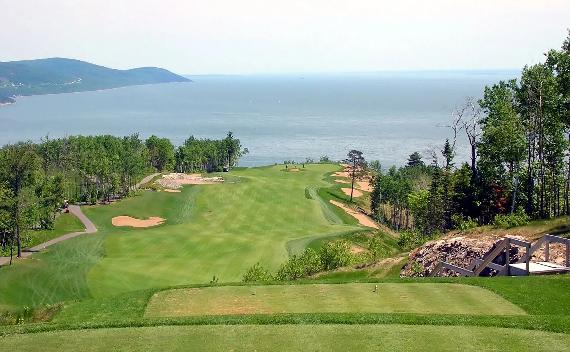 Un parcours de golf qui descend vers le fleuve.